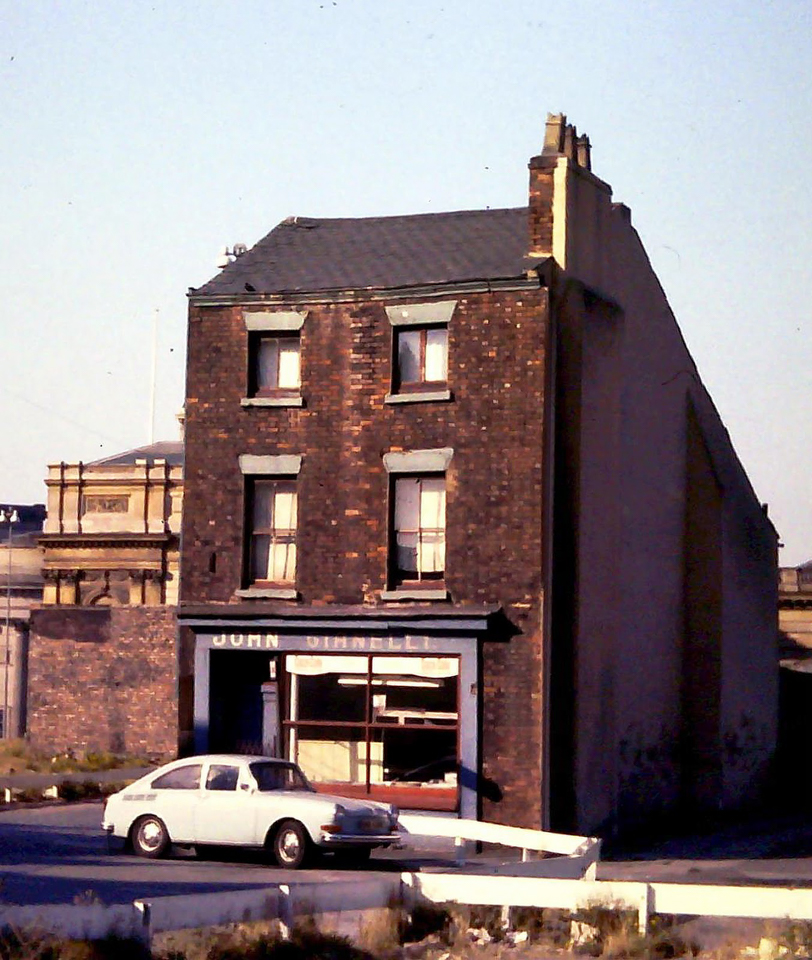 Photo of a building with a fish and chip shop on the ground floor and a car parked out front.